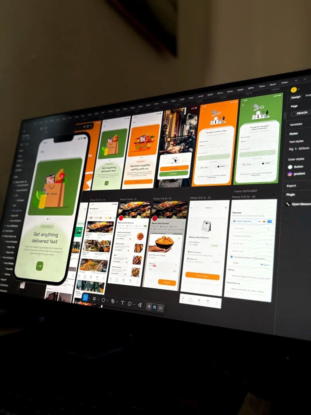 A design tool open on a monitor showing app screens and prototypes